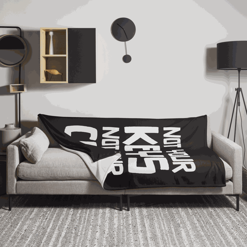 View of a sofa with a black bitcoin blanket.