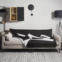 21 Million Bitcoin throw blanket spread across a light grey sofa in a living room, showing the design in a home setting.