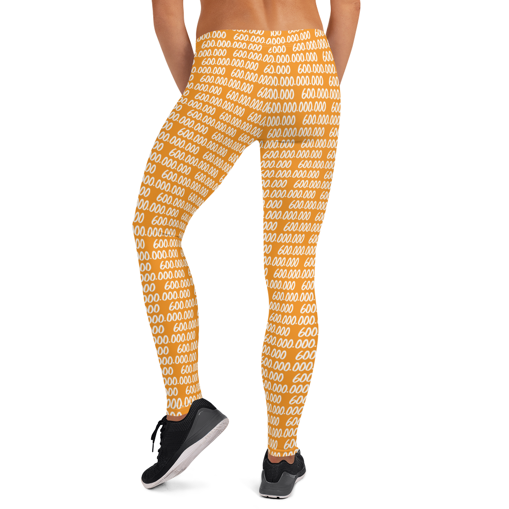 Back view of a woman wearing orange bitcoin leggings.