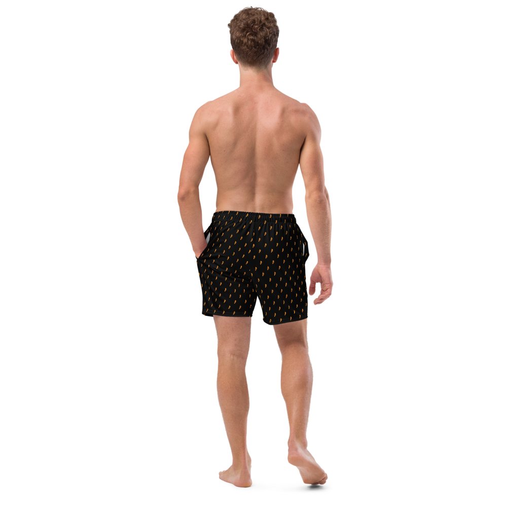 Back view of a man wearing a black bitcoin swim trunks.