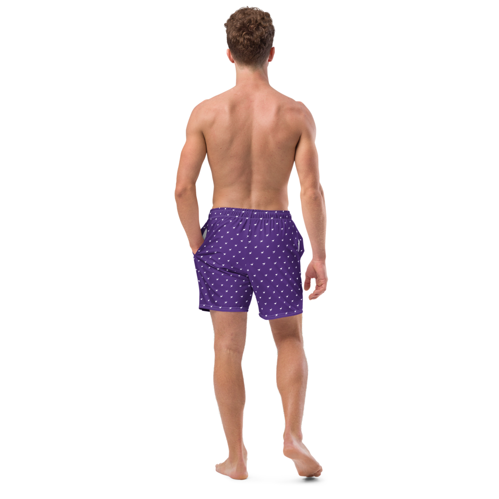 Back view of a man wearing a purple nostr swim trunks.