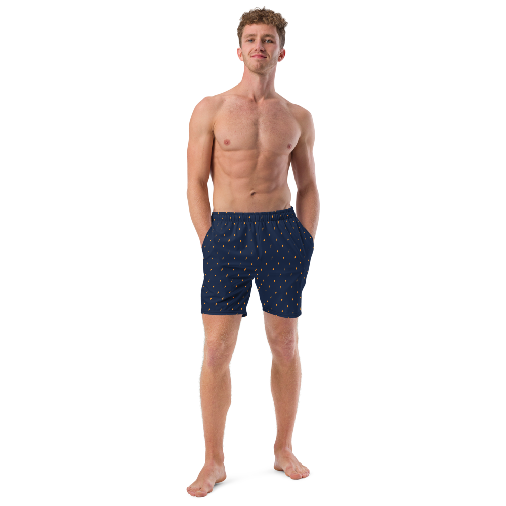 Front view of a man wearing a navy blue bitcoin swim trunks.