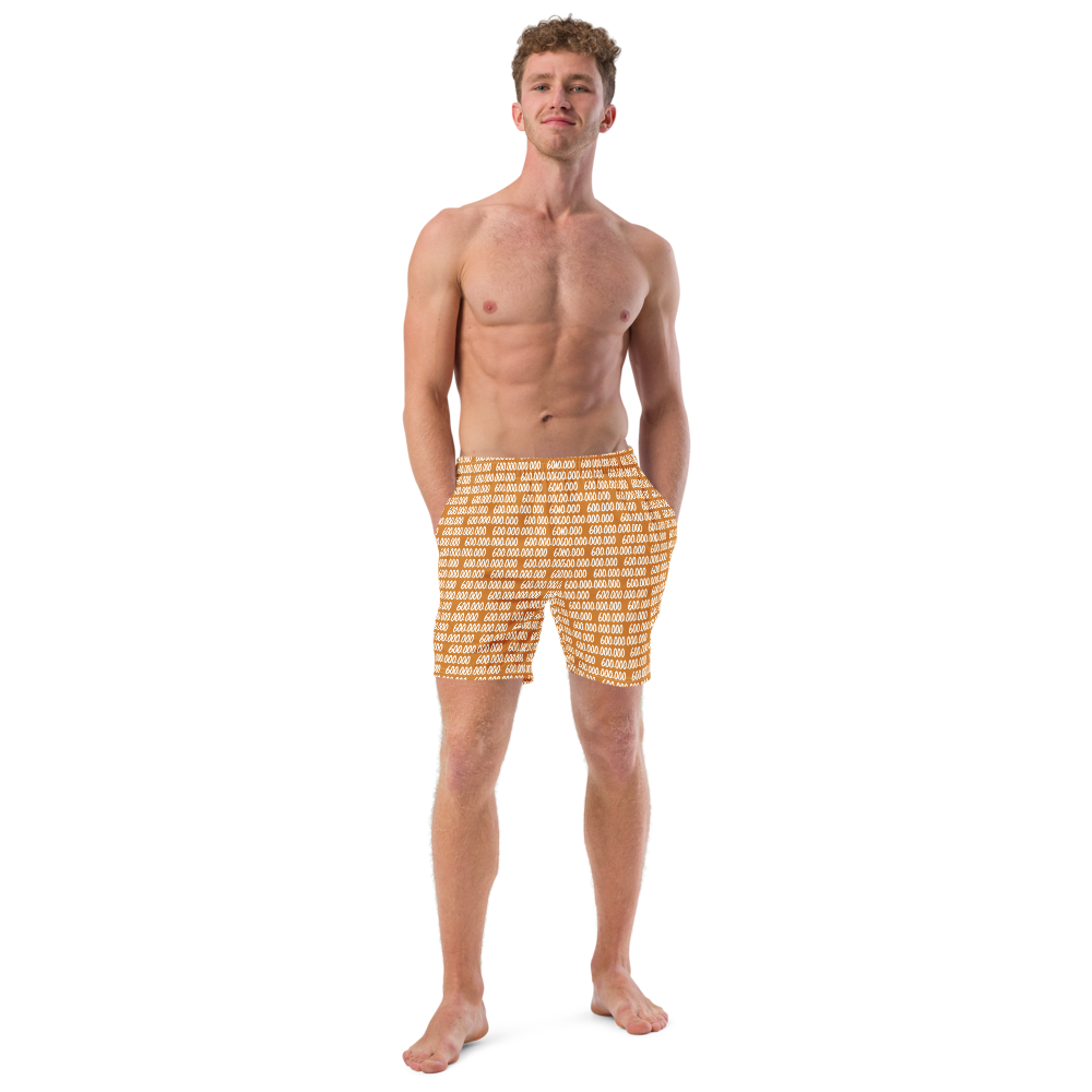 Front view of a man wearing an orange bitcoin swim trunks.