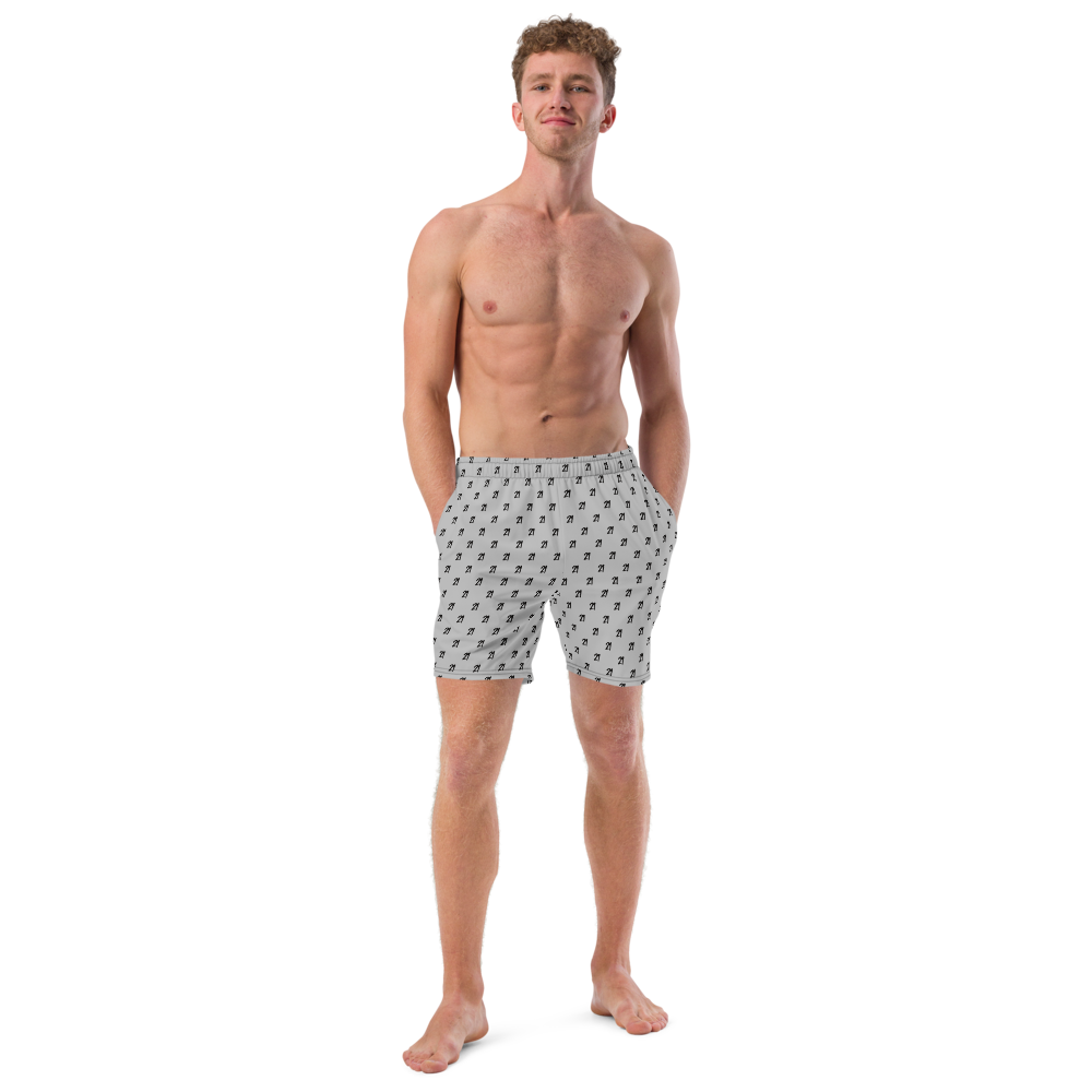 Front view of a man wearing a silver bitcoin swim trunks.