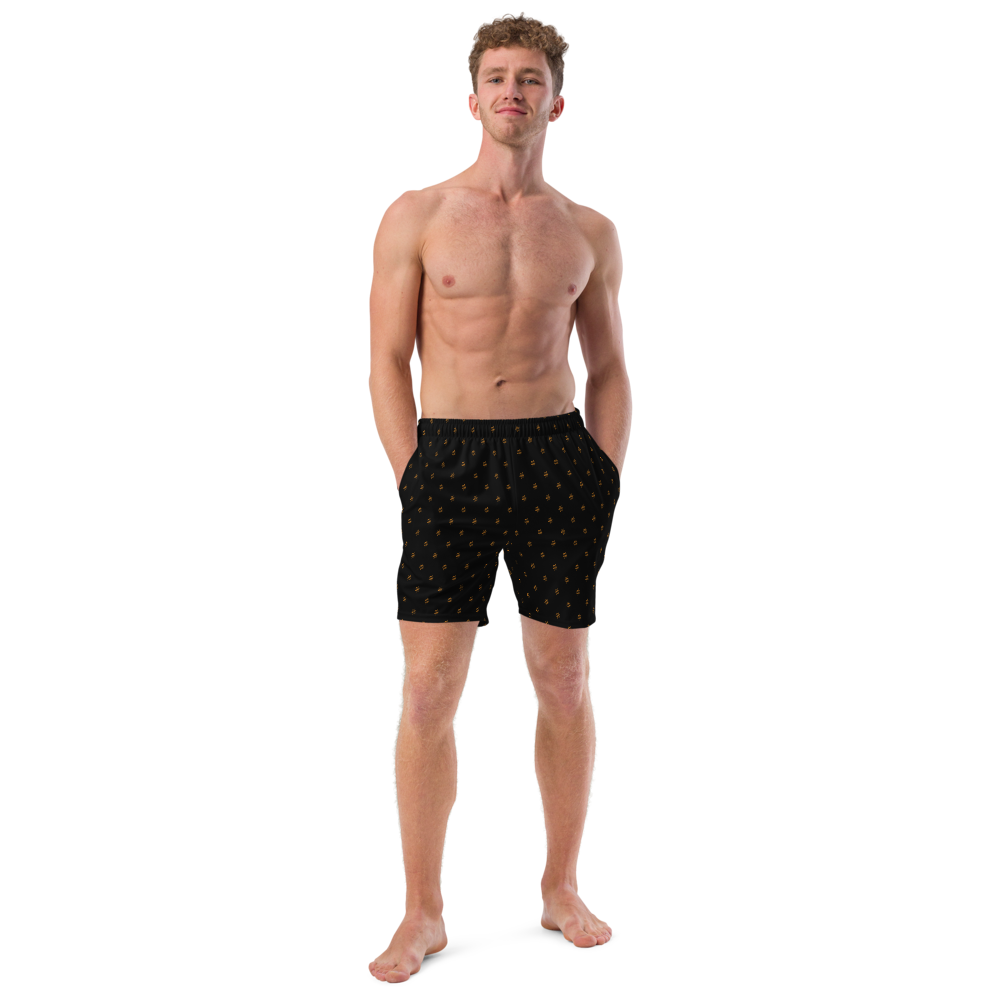 Front view of a man wearing a black bitcoin swim trunks.