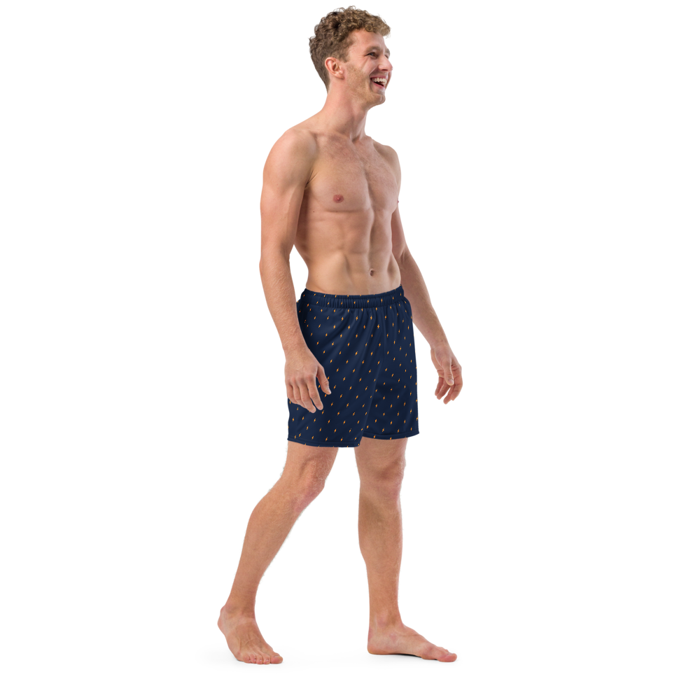 Side view of a man wearing a navy blue bitcoin swim trunks.