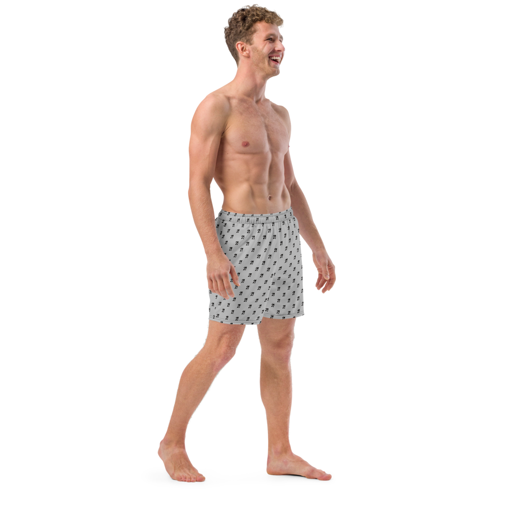 Side view of a man wearing a silver bitcoin swim trunks.