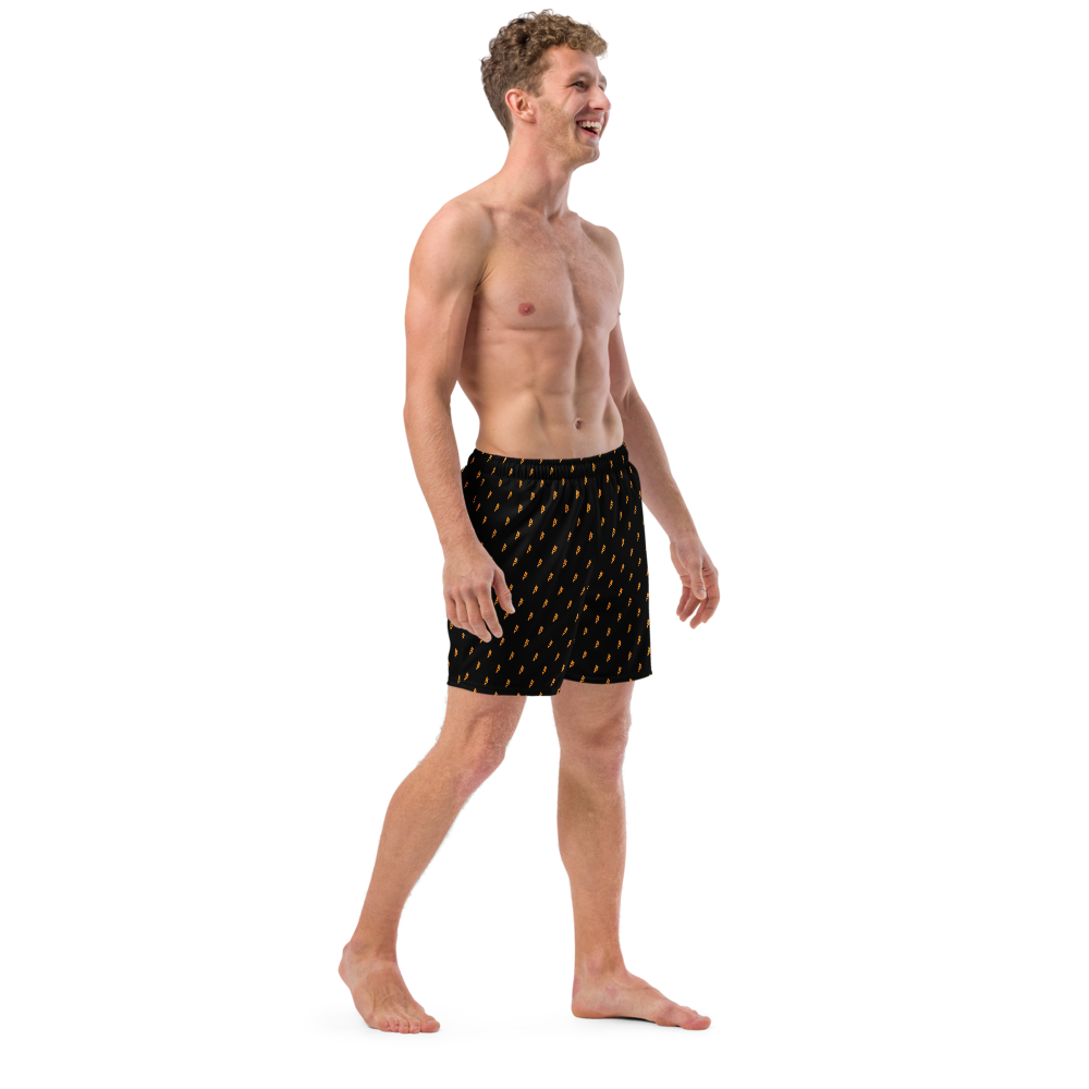 Side view of a man wearing a black bitcoin swim trunks.