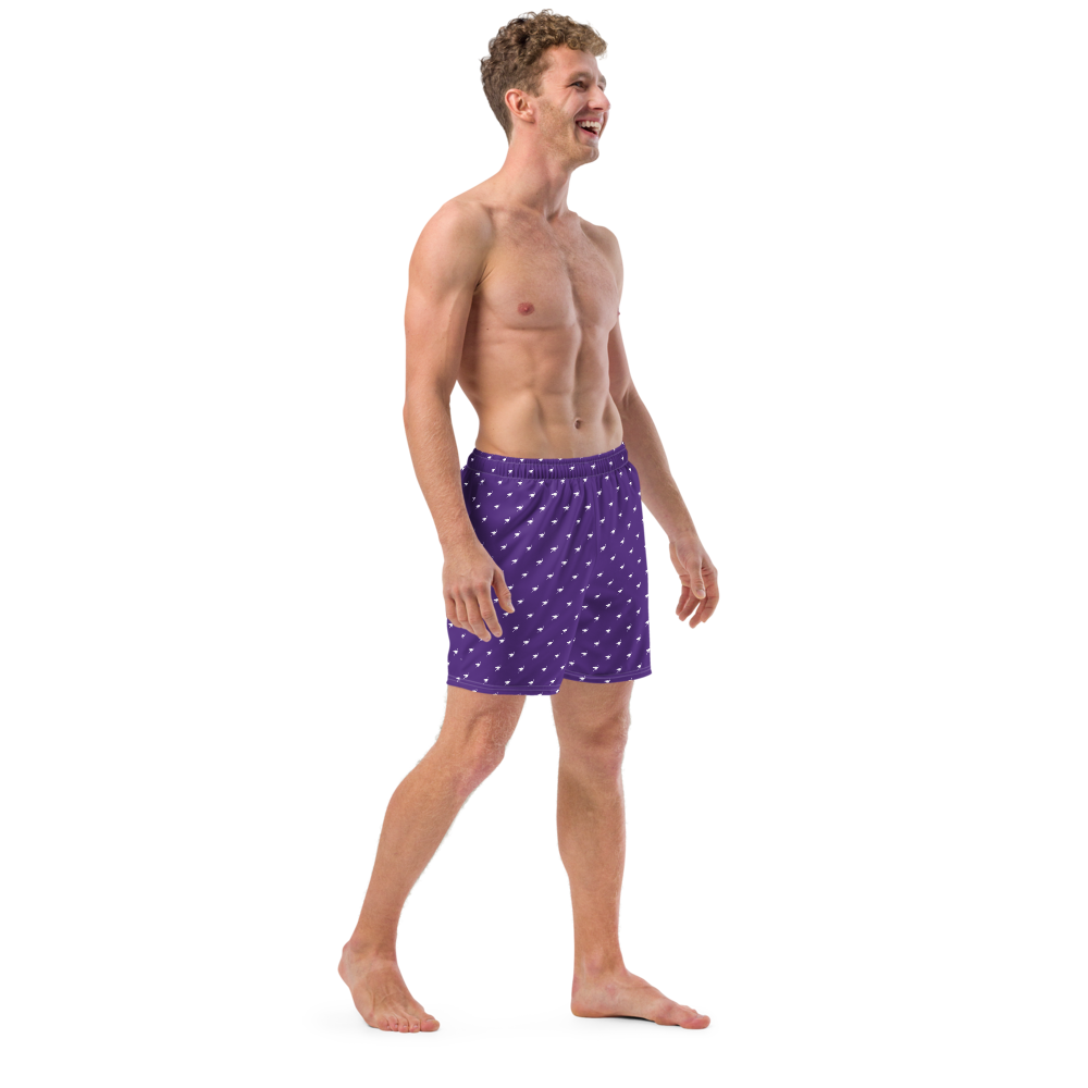 Side view of a man wearing a purple nostr swim trunks.