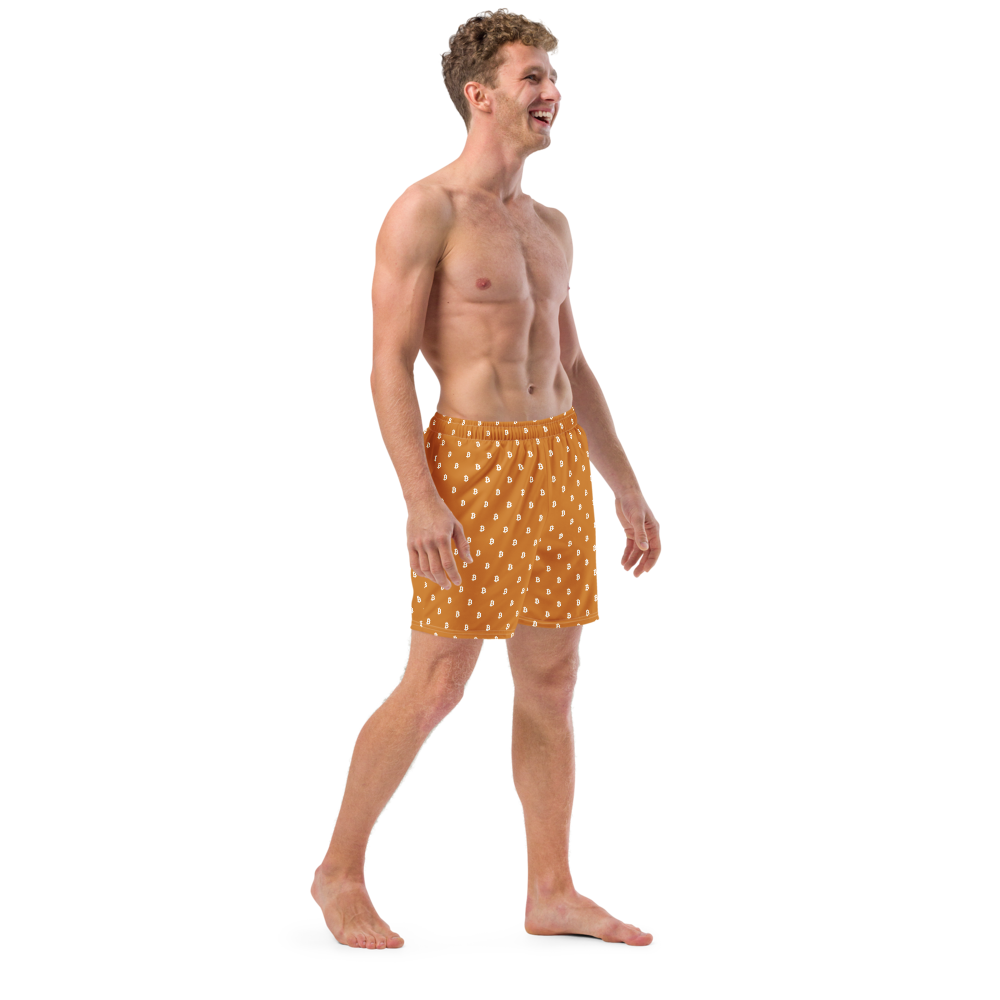 Side view of a man wearing an orange bitcoin swim trunks.