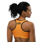 Back view of a woman wearing an orange bitcoin sports bra.