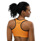 Back view of a woman wearing an orange bitcoin sports bra.