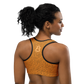 Back view of a woman wearing an orange bitcoin sports bra.