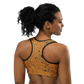 Back view of a woman wearing an orange bitcoin sports bra.