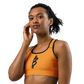 Front view of a woman wearing an orange bitcoin sports bra.