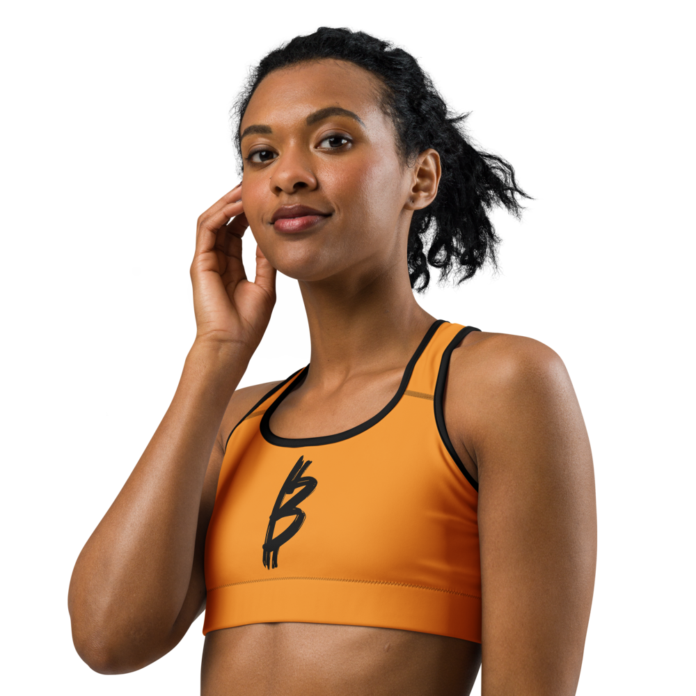 Front view of a woman wearing an orange bitcoin sports bra.