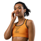 Front view of a woman wearing an orange bitcoin sports bra.