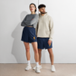 Front view of a man and a woman wearing navy blue bitcoin athletic shorts.