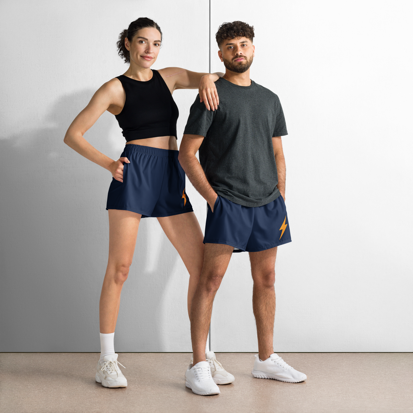 Front view of a man and a woman wearing navy blue bitcoin athletic shorts.