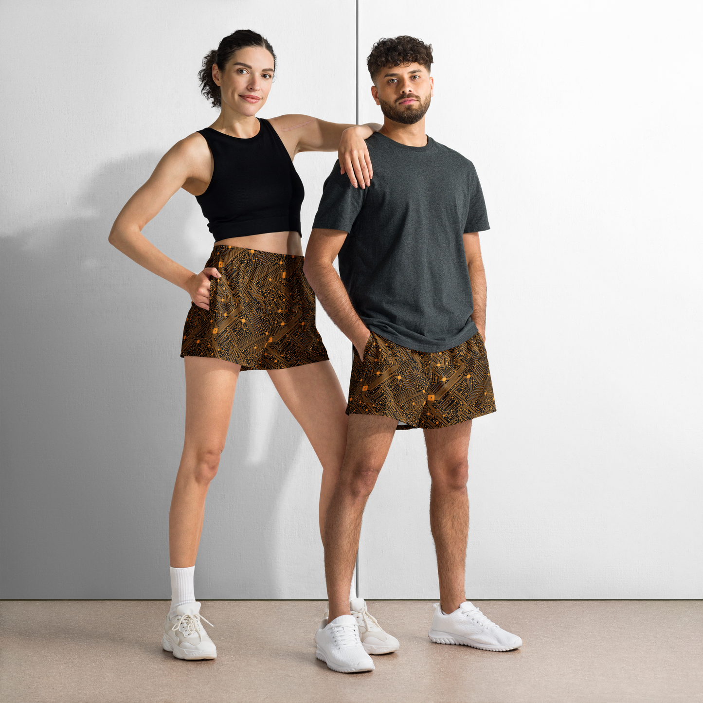 Front view of a man and a woman wearing black and orange bitcoin athletic shorts.