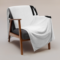 Einundzwanzig Bitcoin throw blanket draped over a wooden armchair, showing the design across the full width of the blanket.