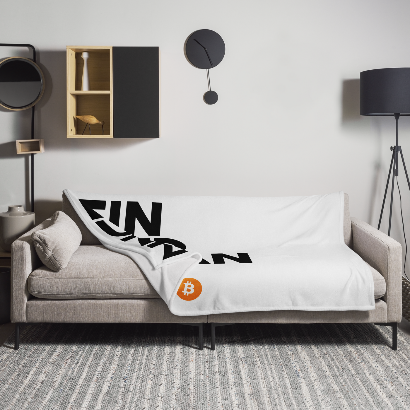 Einundzwanzig Bitcoin throw blanket spread across a light grey sofa in a living room, showing the design in a home setting.