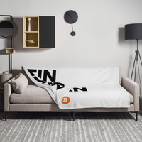 Einundzwanzig Bitcoin throw blanket spread across a light grey sofa in a living room, showing the design in a home setting.