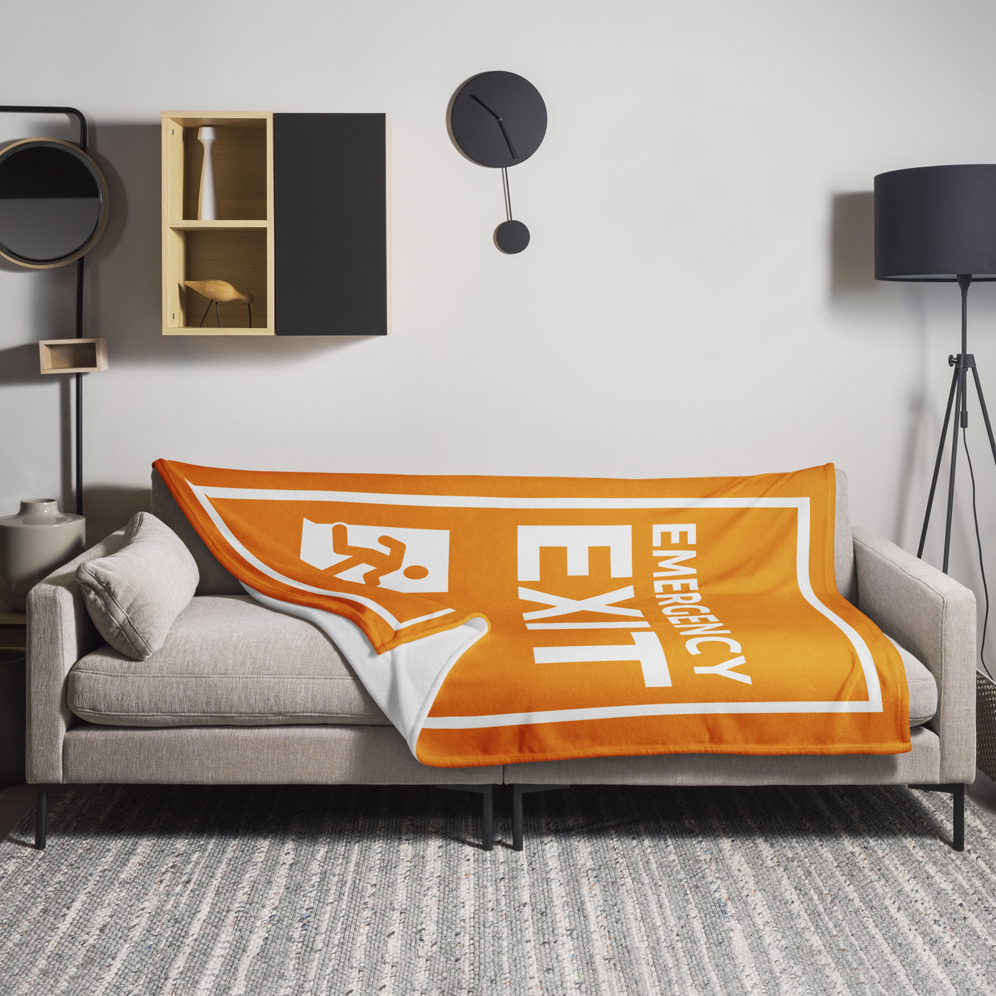 Emergency Exit Bitcoin throw blanket spread across a light grey sofa in a living room, showing the design in a home setting.