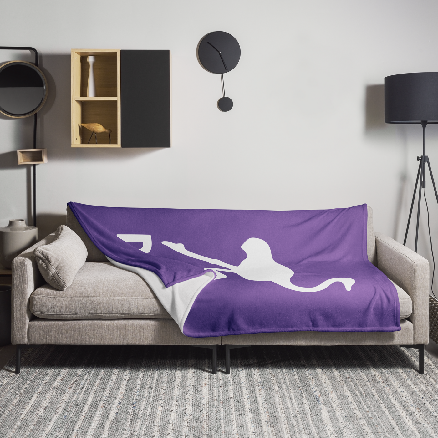 Nostr Nostr throw blanket spread across a light grey sofa in a living room, showing the design in a home setting.