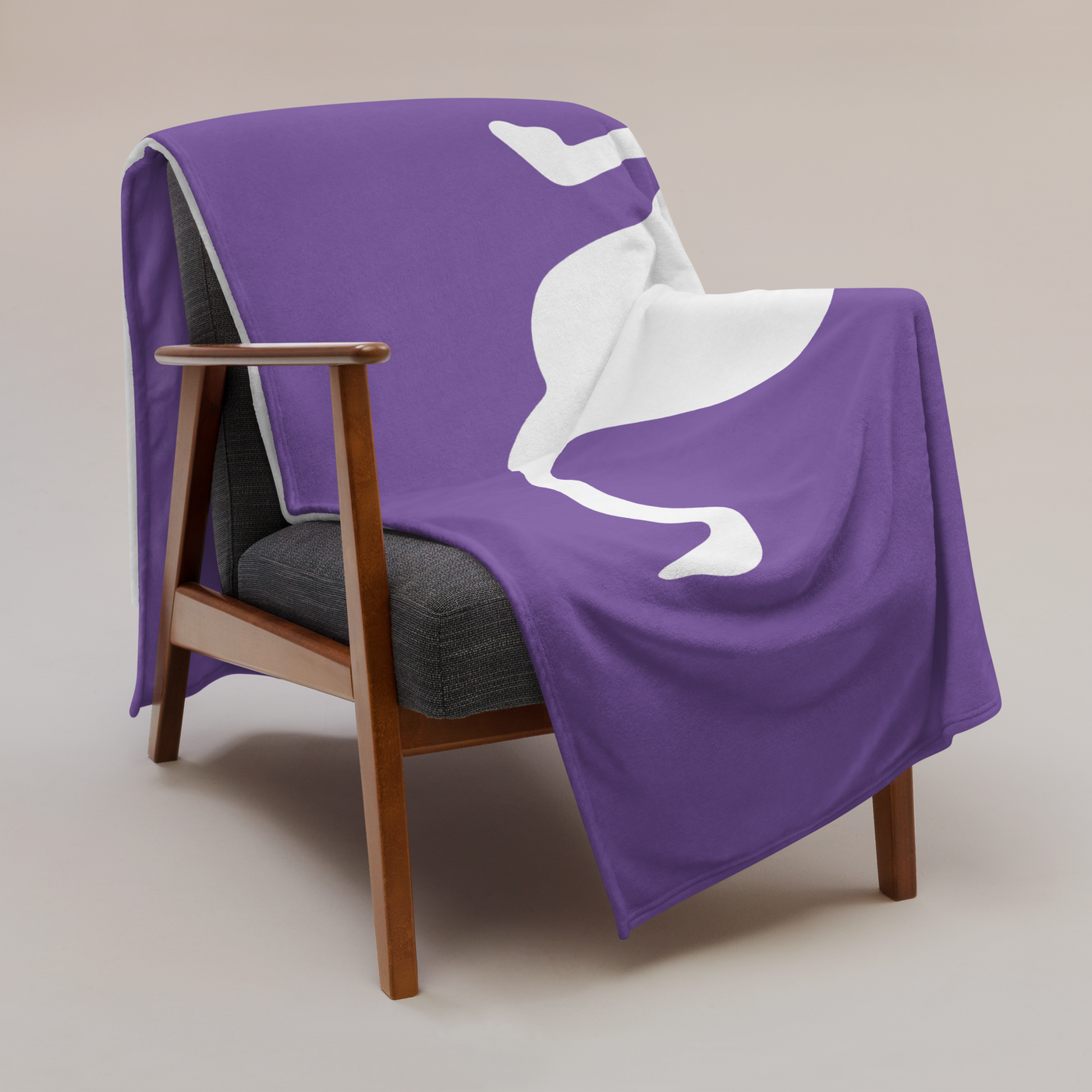 Nostrich Nostr throw blanket draped over a wooden armchair, showing the design across the full width of the blanket.