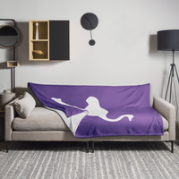 Nostrich Nostr throw blanket spread across a light grey sofa in a living room, showing the design in a home setting.
