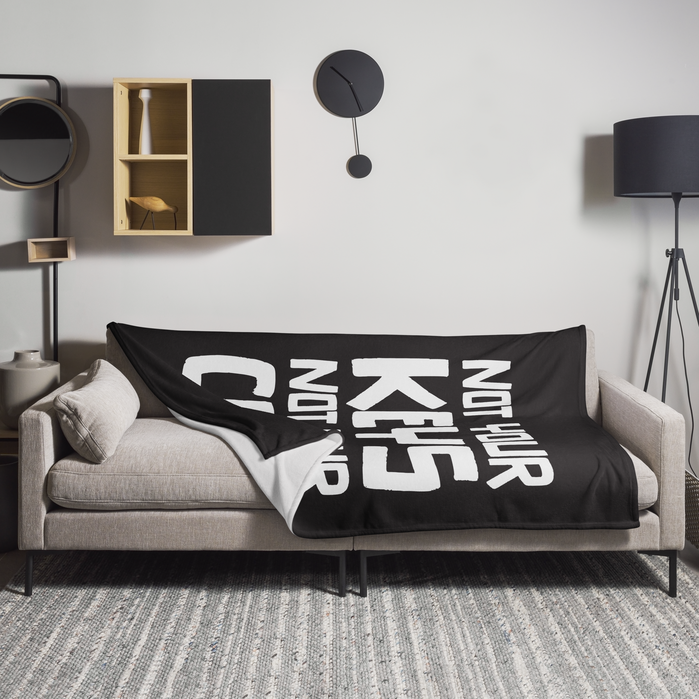 Not your Keys Not your Coins Bitcoin throw blanket spread across a light grey sofa in a living room, showing the design in a home setting.