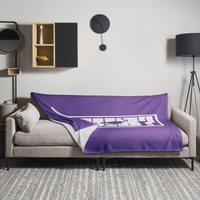 nPub? Nostr throw blanket spread across a light grey sofa in a living room, showing the design in a home setting.