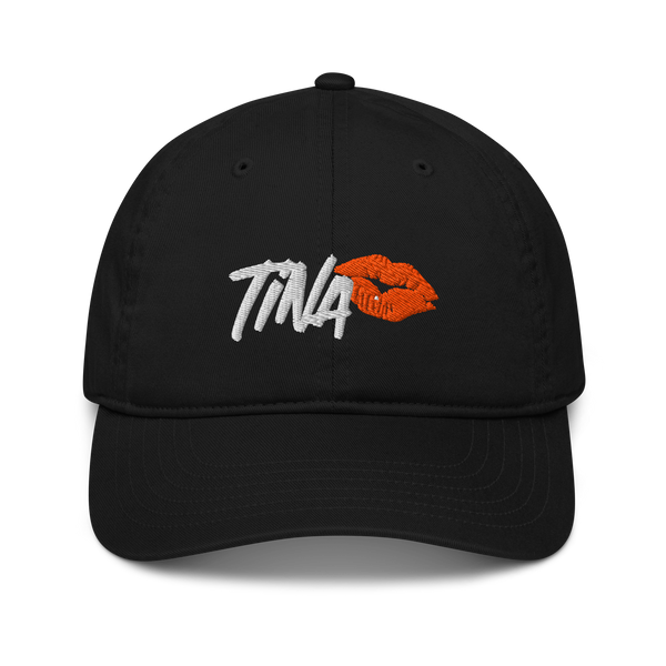 TINA organic bitcoin dad hat, front view: TINA embroidered in white brush lettering beside an orange lipstick kiss, on a dad hat with a curved brim.
