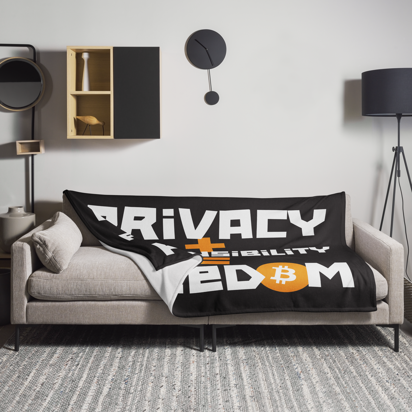 Privacy + Responsibility = Freedom Bitcoin throw blanket spread across a light grey sofa in a living room, showing the design in a home setting.