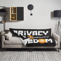 Privacy + Responsibility = Freedom Bitcoin throw blanket spread across a light grey sofa in a living room, showing the design in a home setting.