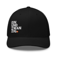 Einundzwanzig bitcoin trucker cap, front view: a black trucker cap with mesh side panels, EIN UND ZWAN ZIG embroidered in white across four lines with a small orange bitcoin coin.