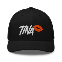 TINA bitcoin trucker cap, front view: TINA embroidered in white brush lettering beside an orange lipstick kiss, on a trucker cap with mesh side panels.