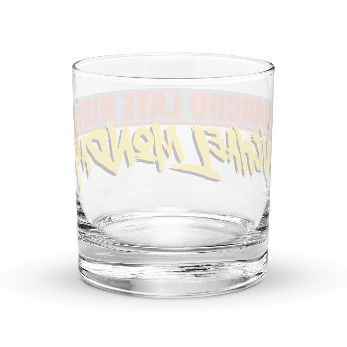 Michael Monday Anarcho Late Night rocks glass, clear 10.5 oz whiskey glass with a band running all the way around: ANARCHO LATE NIGHT in orange on grey above the name Michael Monday in yellow brush script, back view, the band showing through the glass in mirror image.