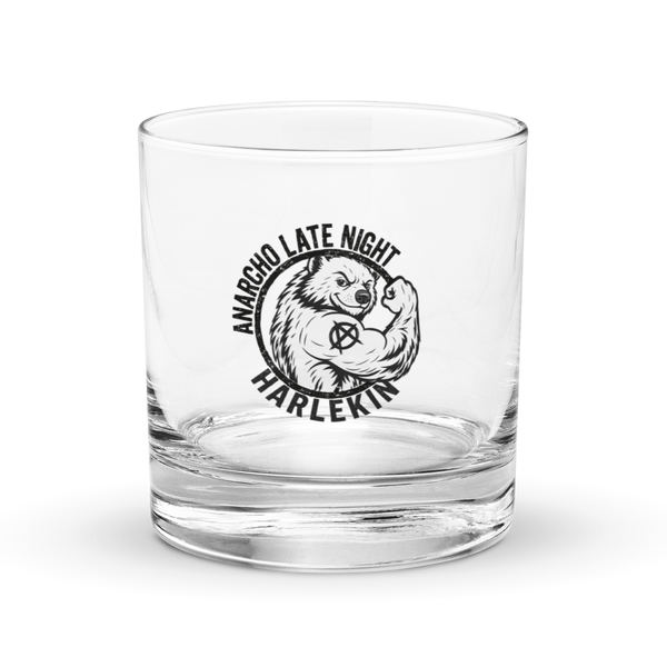 Anarcho Late Night Logo Rocks glass anarcho late night logo rocks glass, front view: a clear rocks glass carrying the circular ANARCHO LATE NIGHT HARLEKIN badge in black, a flexing bear with an anarchy symbol.