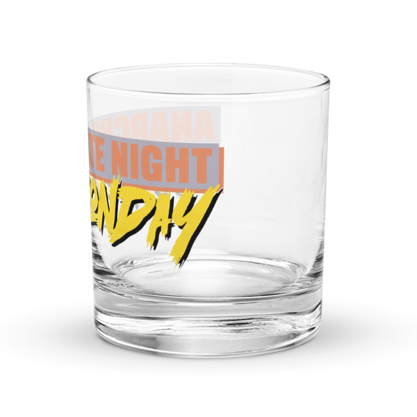 Michael Monday Anarcho Late Night rocks glass, clear 10.5 oz whiskey glass with a band running all the way around: ANARCHO LATE NIGHT in orange on grey above the name Michael Monday in yellow brush script, left side view showing LATE NIGHT and the end of the name.