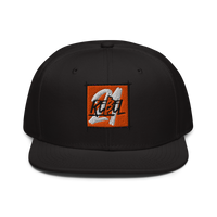 21 Rebel bitcoin snapback hat, front view: a black snapback with a flat brim and an embroidered orange square patch carrying the 21 Rebel graffiti mark in white and grey.