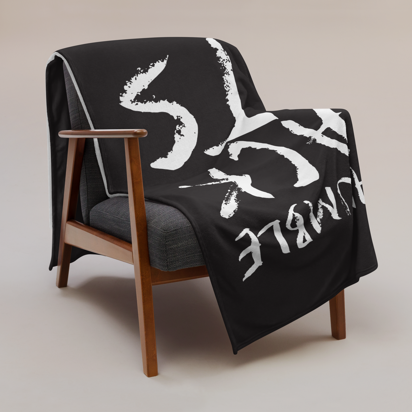 Stay Humble Stack Sats Bitcoin throw blanket draped over a wooden armchair, showing the design across the full width of the blanket.