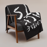 Stay Humble Stack Sats Bitcoin throw blanket draped over a wooden armchair, showing the design across the full width of the blanket.