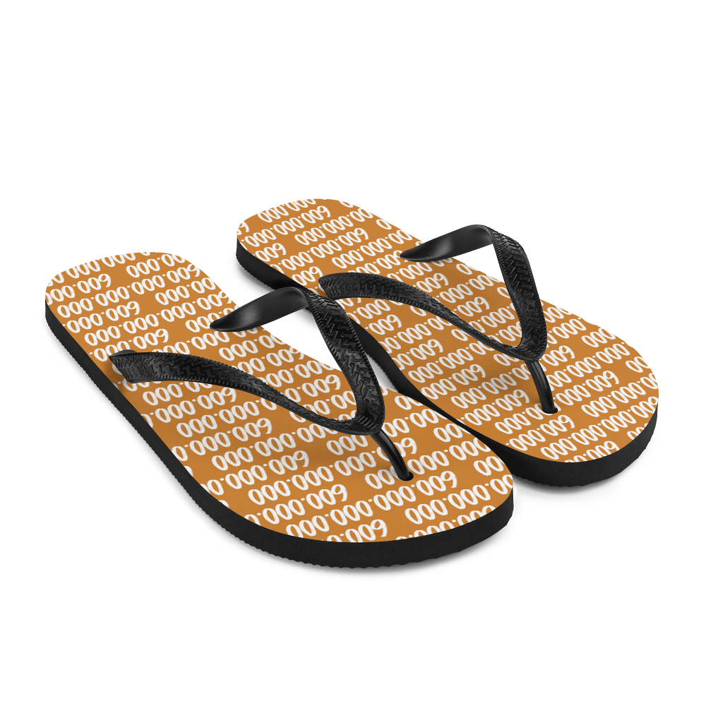 Side view of a pair of orange and black bitcoin flip flops.