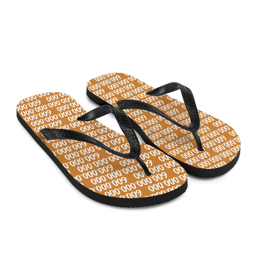 Side view of a pair of orange and black bitcoin flip flops.