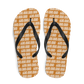 Top view of a pair of orange and black bitcoin flip flops.