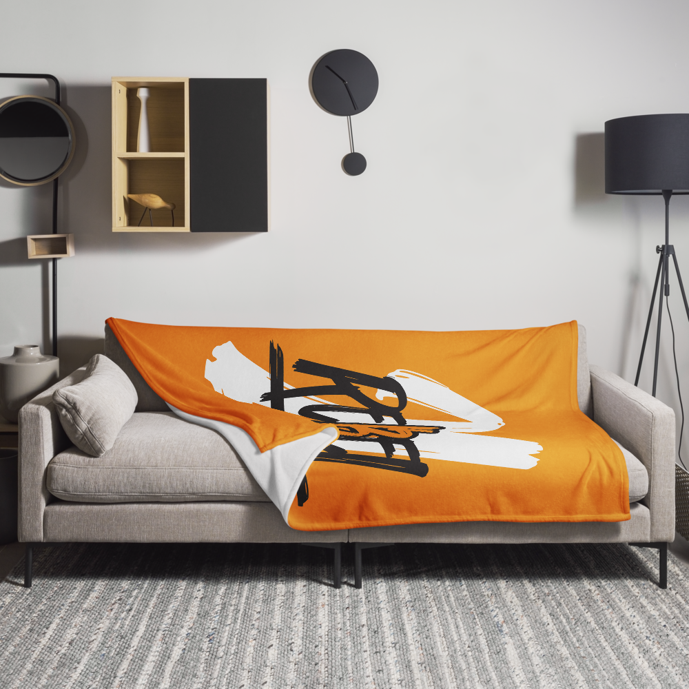 View of a sofa with an orange bitcoin blanket.